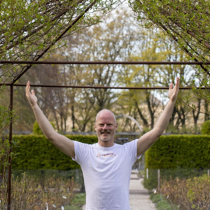 man standing in a garden doing qigong