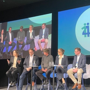 people sitting on a stage talking to the audience